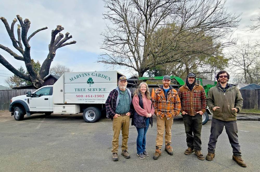 The Marvin's Garden Tree Service family crew standing in front of their chip truck and chipper in Willits, CA